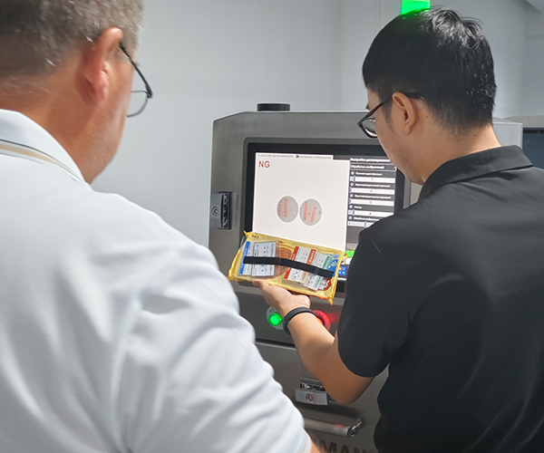 Foodman service engineer providing on-site installation guidance for inspection system at food processing facility