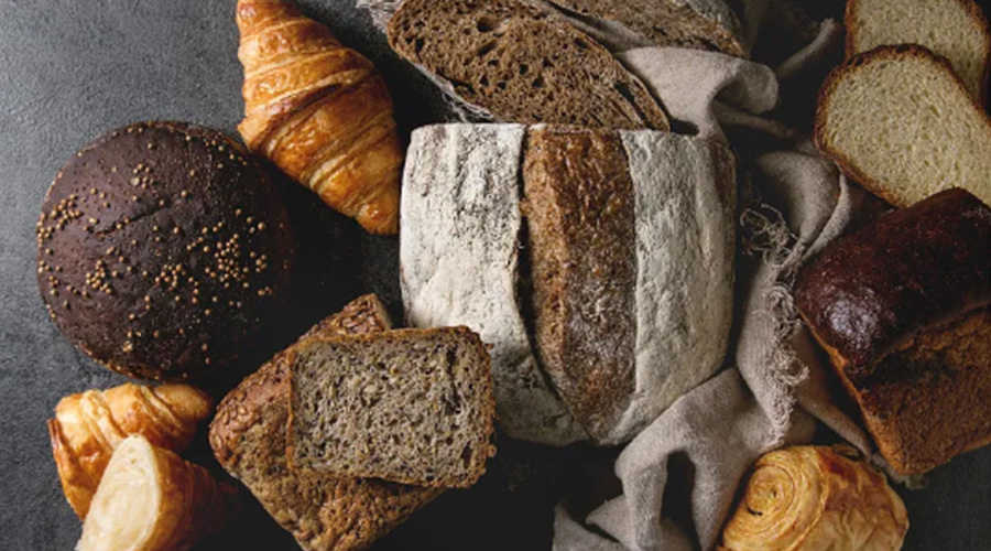 Freshly baked bread loaves passing under Foodman vision inspection system for surface color and appearance check