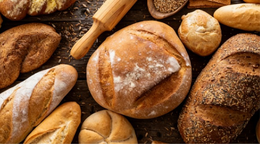 Freshly baked bread and pastries on a cooling rack representing finished bakery products