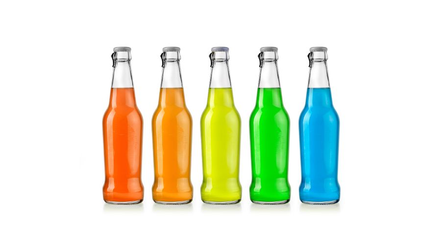 Assorted glass bottles of soda and metal cans of food products on a conveyor for X-ray inspection