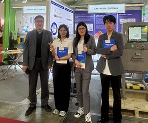 Foodman team group photo at international food safety exhibition booth with branded uniforms and equipment display