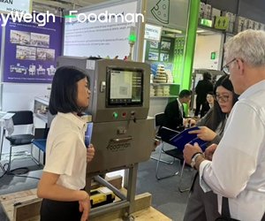 Technical expert demonstrating X-ray inspection system features to a group of visitors at Foodman exhibition booth