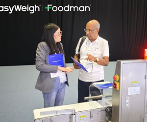 EasyWeigh specialist demonstrating PC-controlled dynamic checkweigher to customer at trade show