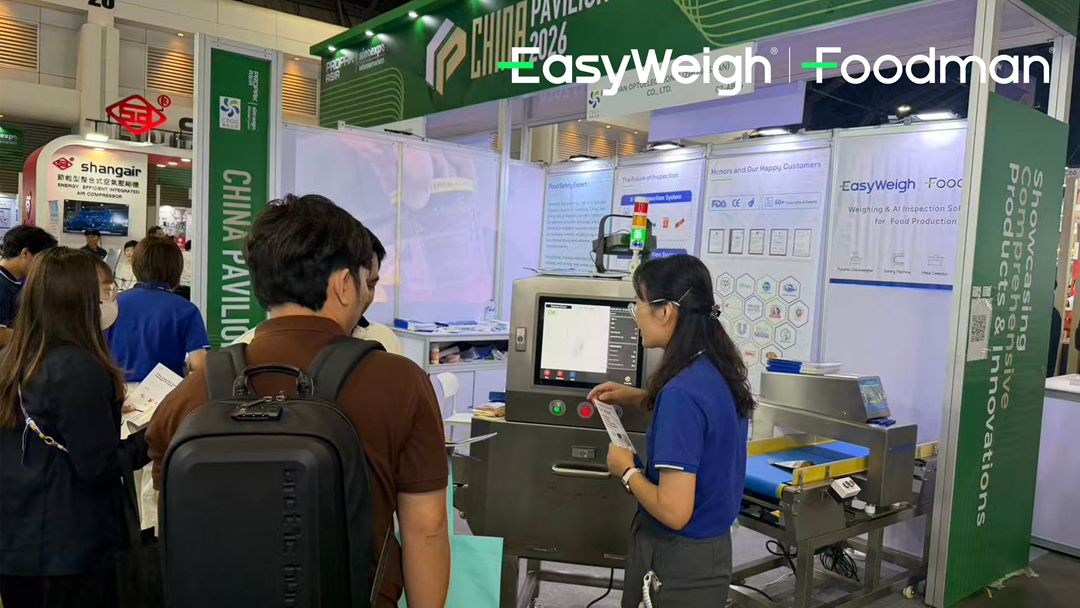 Foodman technical expert explaining X-ray inspection system features and dual-beam technology to attendees